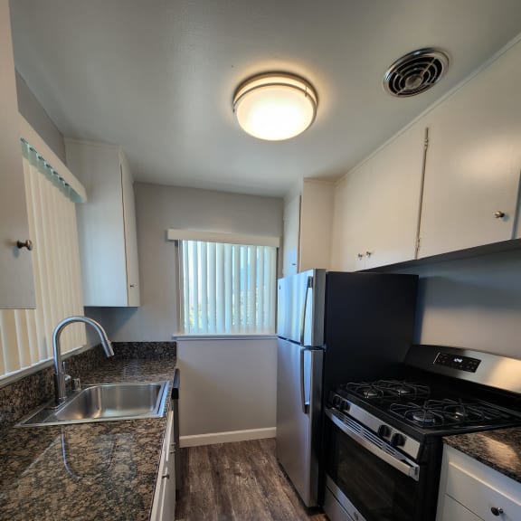 a kitchen with a sink and a counter top and a window