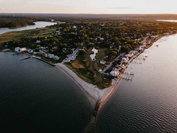 A small town is situated on the edge of a large body of water.