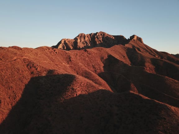 a mountain with a blue sky in the background