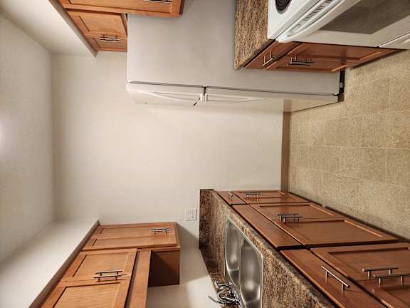 a kitchen with wooden cabinets and a stainless steel sink and a dryer