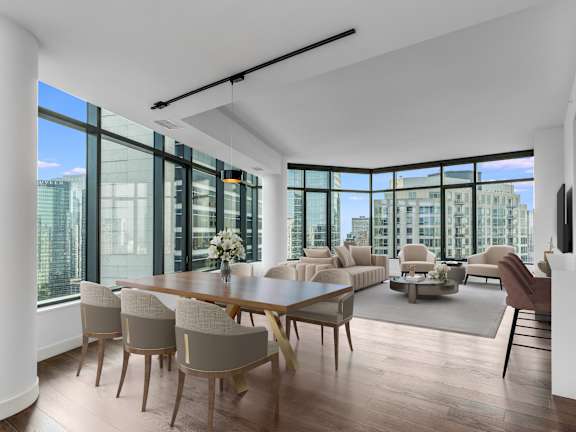 a large living room with a large table and chairs and a view of the city