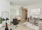 Thumbnail 2 of 21 - A room with a desk, chair, and exercise bike at One 333, Chicago, IL