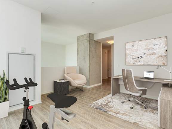 A room with a desk, chair, and exercise bike at One 333, Chicago, IL