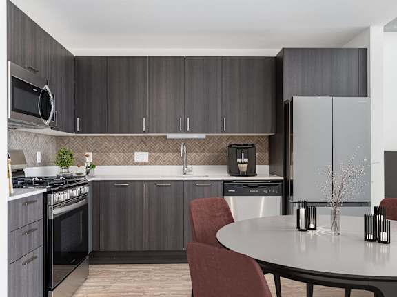A modern kitchen with a grey color scheme and a white dining table at One 333, Chicago, Illinois