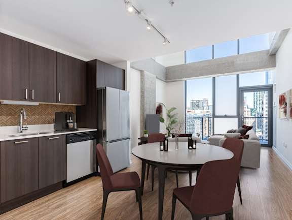 A modern kitchen with brown cabinets and a dining table with four chairs at One 333, IL, 60605