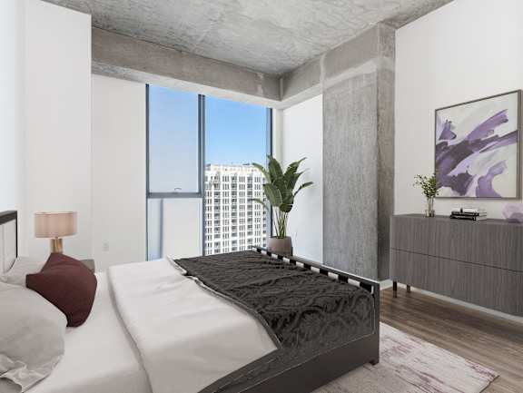 A modern bedroom with a large bed and a view of the city at One 333, Chicago, IL