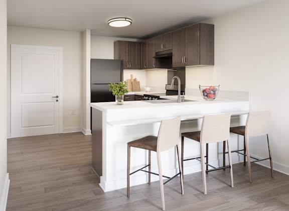 A kitchen with a white island and brown chairs. at Divinity Landing Apartments, Macedonia, 44056
