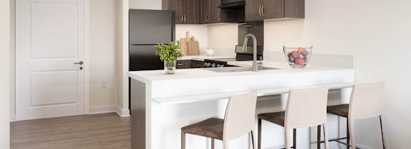 A kitchen with a white island and brown chairs.