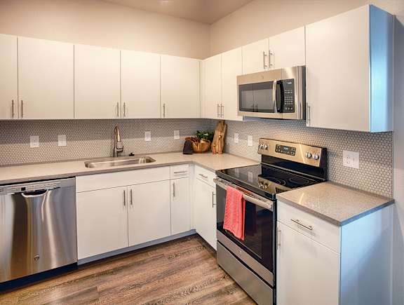 a kitchen with stainless steel appliances and white cabinets