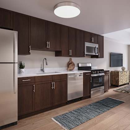 A modern kitchen with wooden cabinets and stainless steel appliances. at Oskamp Flats Apartments, Cincinnati, OH