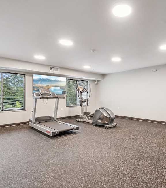 A room with a treadmill and exercise bike.