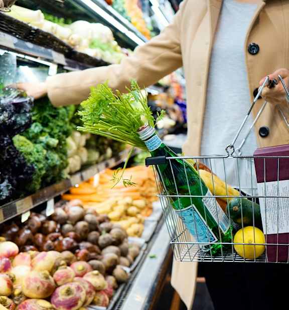 A person is shopping for vegetables in a grocery store.