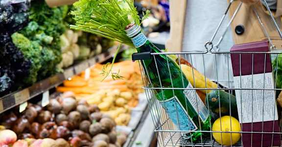 A person is shopping for vegetables in a grocery store.