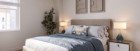 A bedroom with a bed, nightstand, and a ceiling fan.
