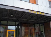 Thumbnail 17 of 23 - the front of a building with a yellow door