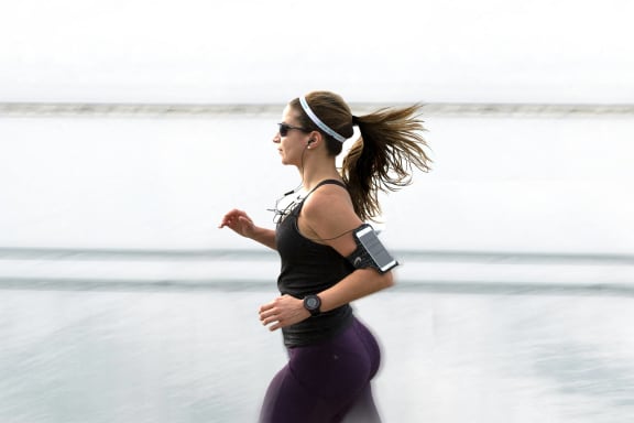 a woman running on the beach in her workout gear
