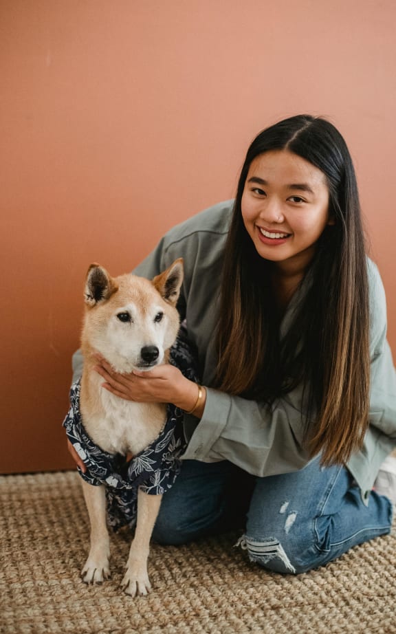 a woman sitting on the floor with a dog
