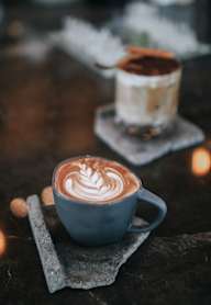 A cup of coffee with a latte art design on top.