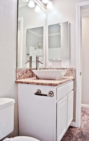 A white bathroom with a sink and mirror.