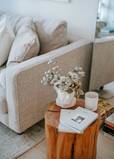 a living room with a couch and a coffee table with a vase of flowers
