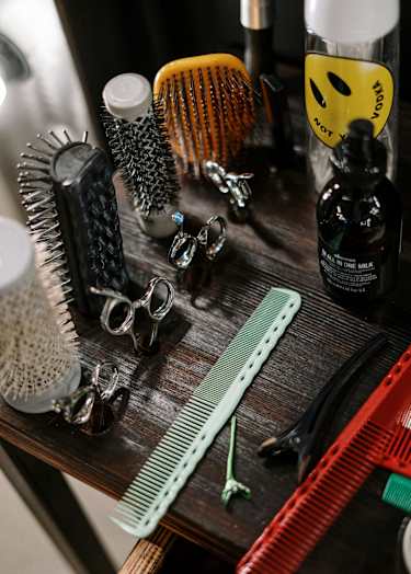 A collection of hair styling tools are displayed on a wooden surface.