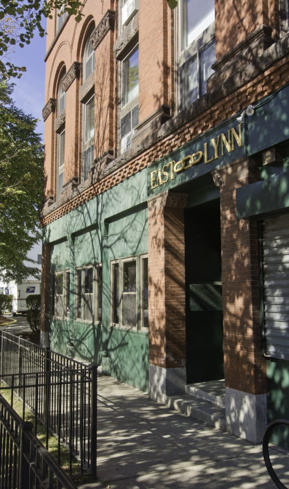 an old building with a green facade and a sidewalk
