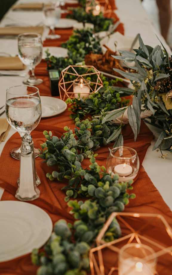 A table set for a meal with greenery and candles.