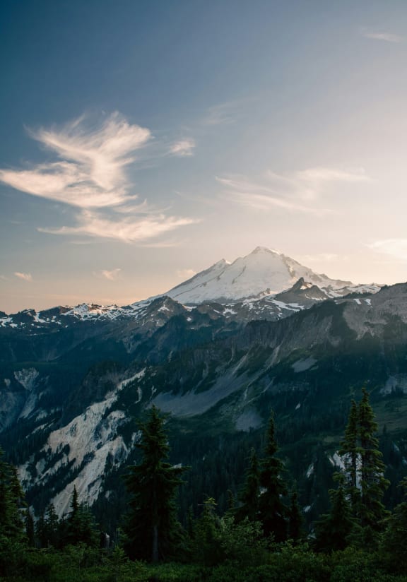 a view of a snow covered mountain with a blue sky