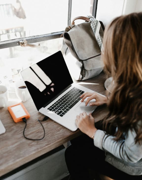 a woman sitting at a table using a laptop computer