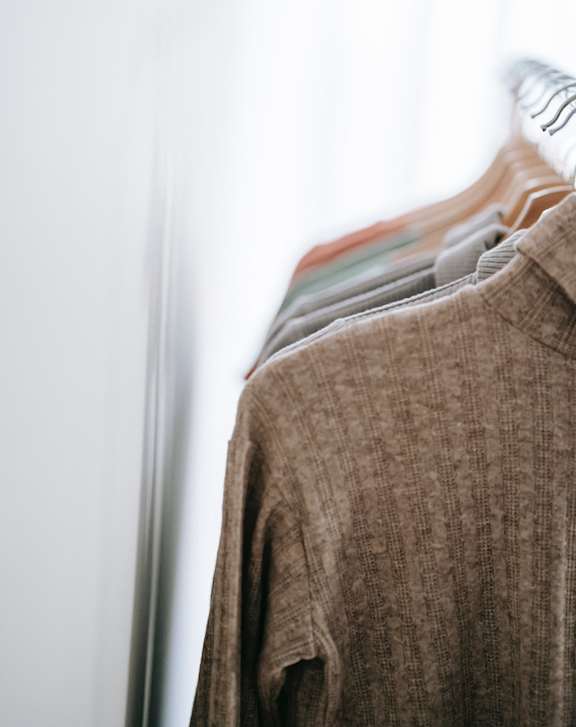 A row of clothes hanging on a rack.
