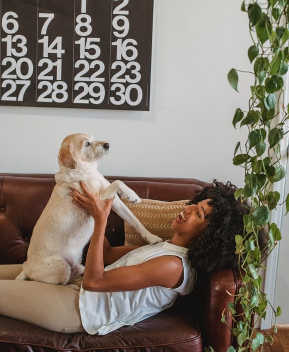 a woman sitting on a couch with her dog