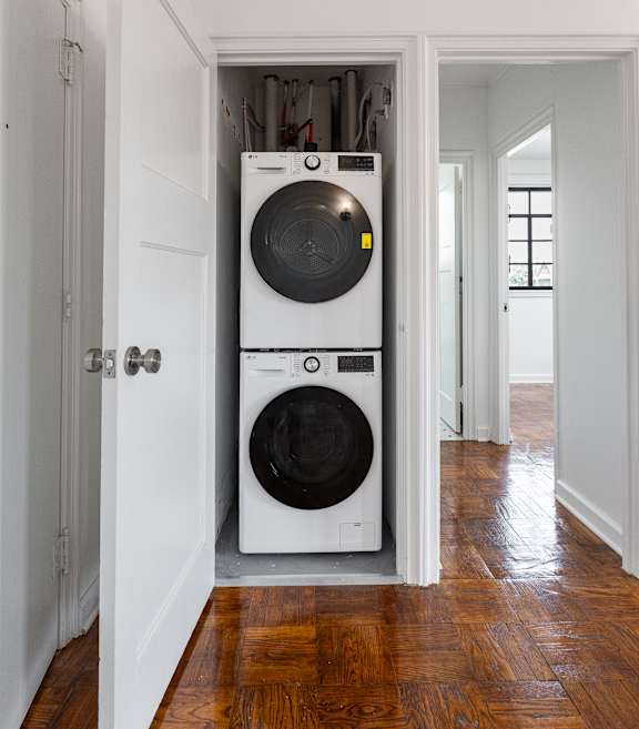 A white washer and dryer in a small room.