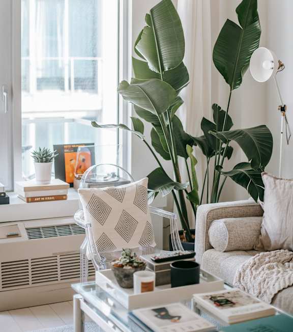 A wooden shelf with a woven basket, a white vase, and a white pillow.
