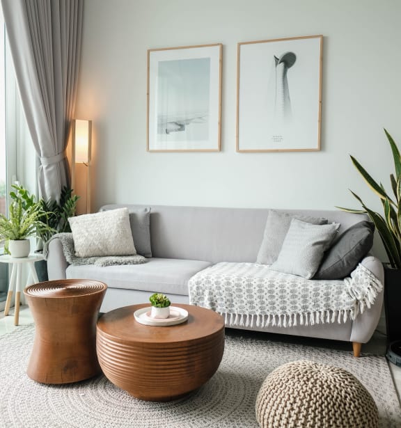 a living room with a grey couch and two coffee tables