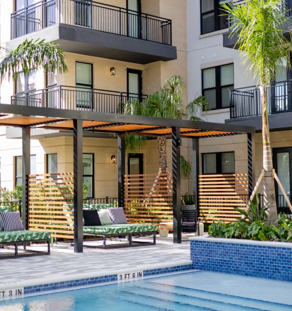 a swimming pool in front of an apartment building with palm trees  at La Unión, Tampa, 33605
