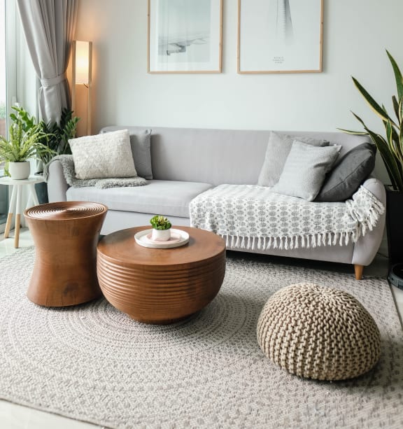 a living room with a grey couch and two coffee tables