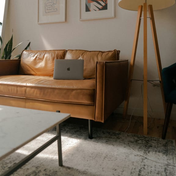 a living room with a couch and a laptop on it