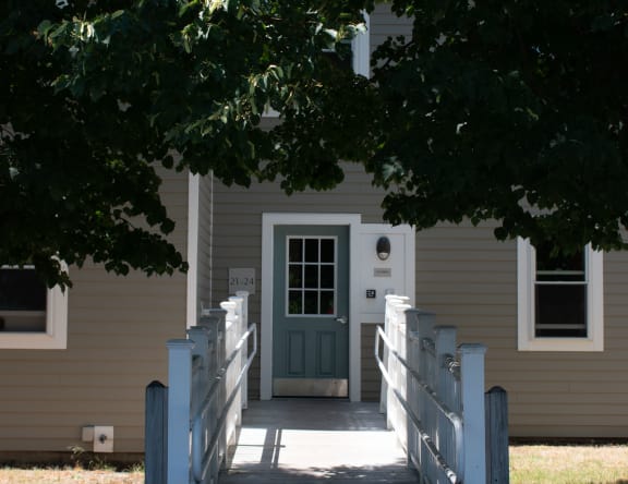 a white house with a white walkway and a green door