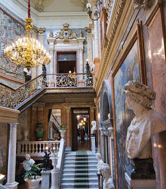 a large room with a chandelier and paintings on the wall