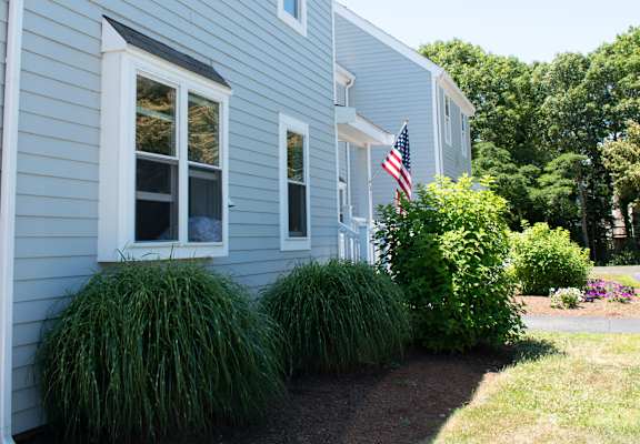 a blue house with an flag in the front yard