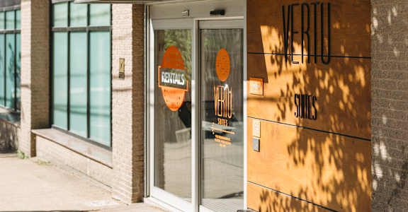 A storefront with a black awning and a glass door with a sign that says "Nordstrom.".