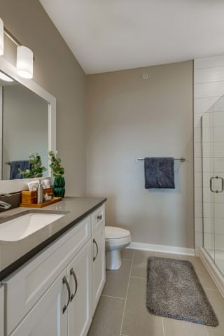 Master bathroom with tile shower and quartz countertops in 2 bedroom apartment for rent at Ascend at Woodbury best apartments Woodbury MN 55129