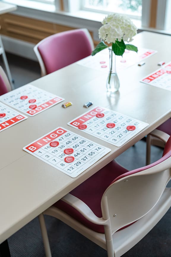 A table with a vase of flowers and a bingo card on it.