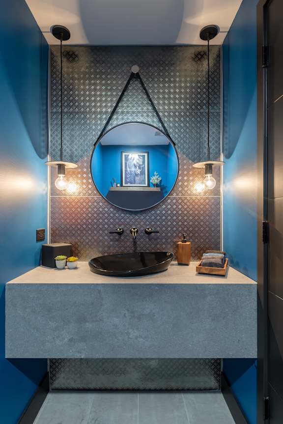 a bathroom with blue walls and a sink and a mirror