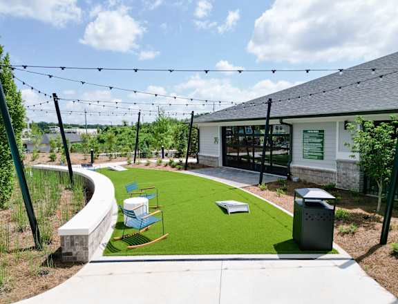 A playground area with a slide and a green lawn.