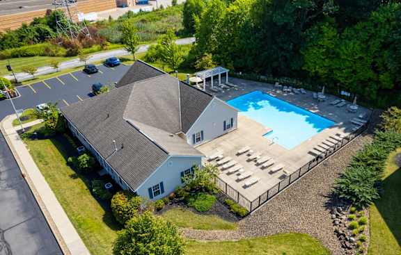 Apartments for Rent in Wadsworth, OH - Stratford Crossings - Pool with Sun Lounge Chairs, Trees, and Landscaping