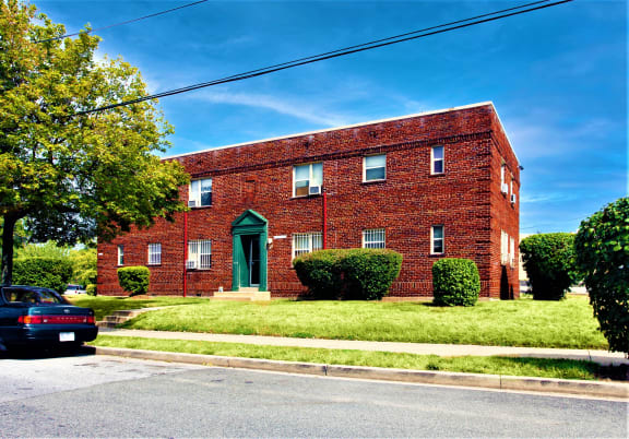 a red brick building with a green door and a blue sky in the background