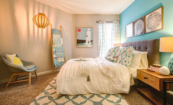 A bedroom with a white bed and a blue wall at Waverly Place, North Charleston, SC, 29418
