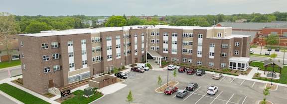 A modern apartment building with a car parked in front.