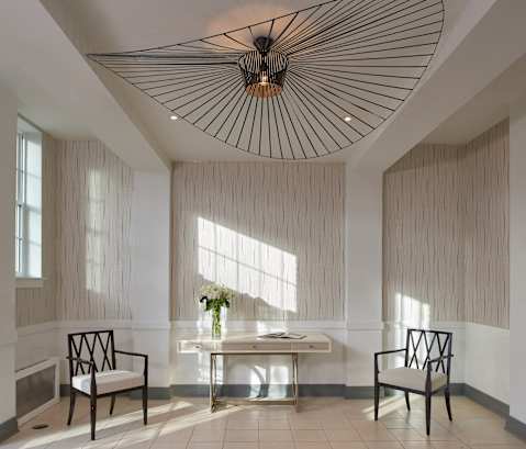 a lobby with a table and chairs and a large chandelier